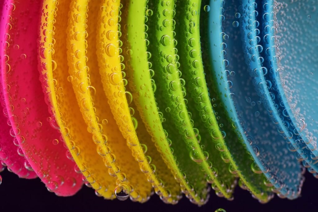 Close-up of colorful plastic discs with water bubbles highlighting vibrant hues.