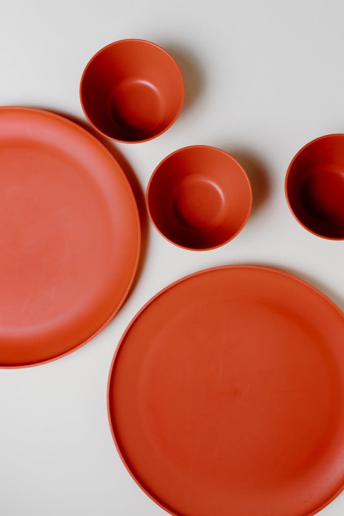 about-01 Stylish flat lay of orange bowls and plates showcasing minimalist tableware design.